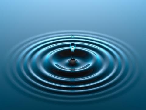 A drop causing water to ripple outwards