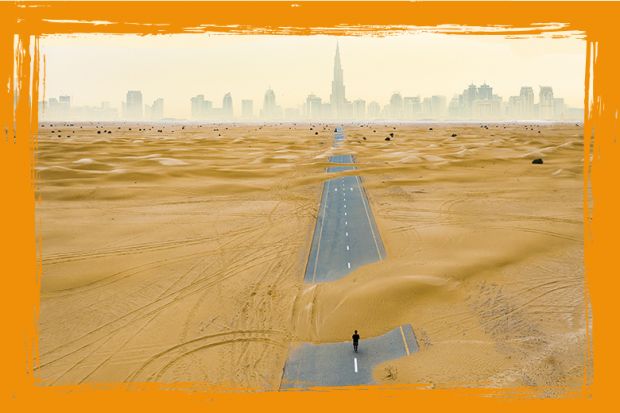 aerial view of an unidentified person walking on a deserted road covered by sand dunes in the middle of the Dubai desert.  Dubai, United Arab Emirates.